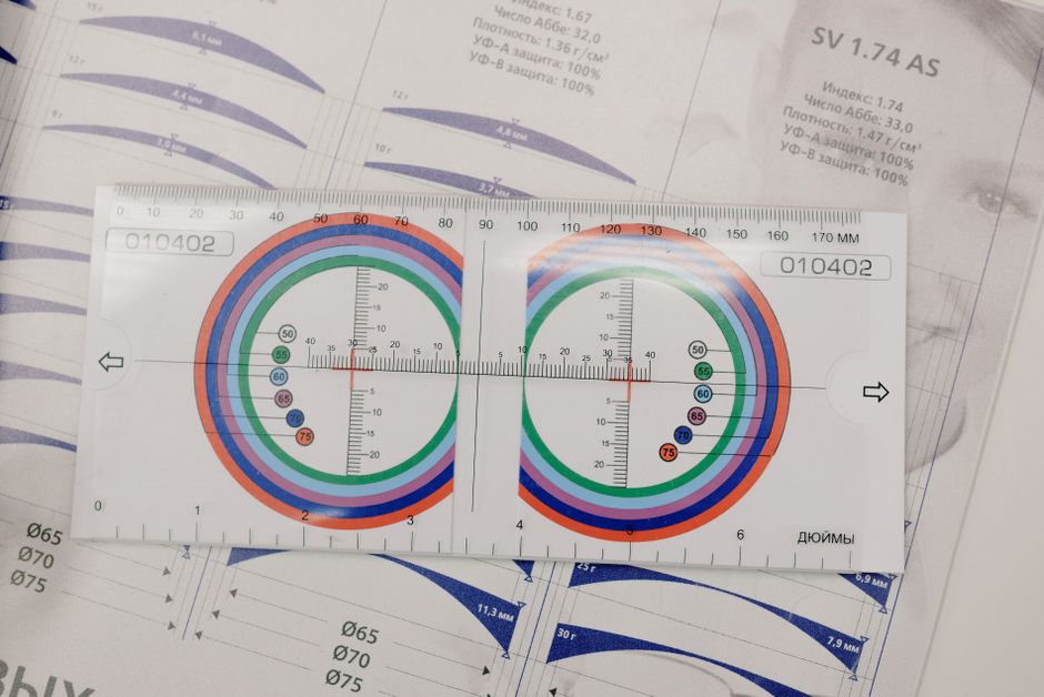 From above of manual optical tool with numbers and arrows on paper with brochure on table